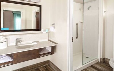 Guest bathroom with shower at Hampton Inn & Suites By Hilton Atlanta Perimeter Dunwoody.