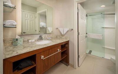 Private guest bathroom with shower and free toiletries at Sonesta ES Suites Baltimore BWI Airport.