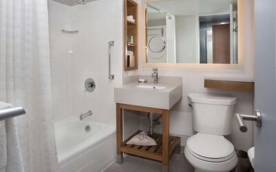Private guest bathroom with combined shower and tub at New York Hilton Midtown.