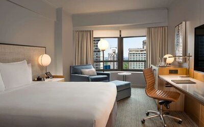 King room with work desk and sofa at New York Hilton Midtown.