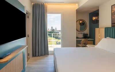 King bed with TV at Terradamari Resort & Spa Marina Di Modica.