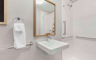 Private guest bathroom with shower and free toiletries at Sonesta Simply Suites Baltimore BWI Airport.