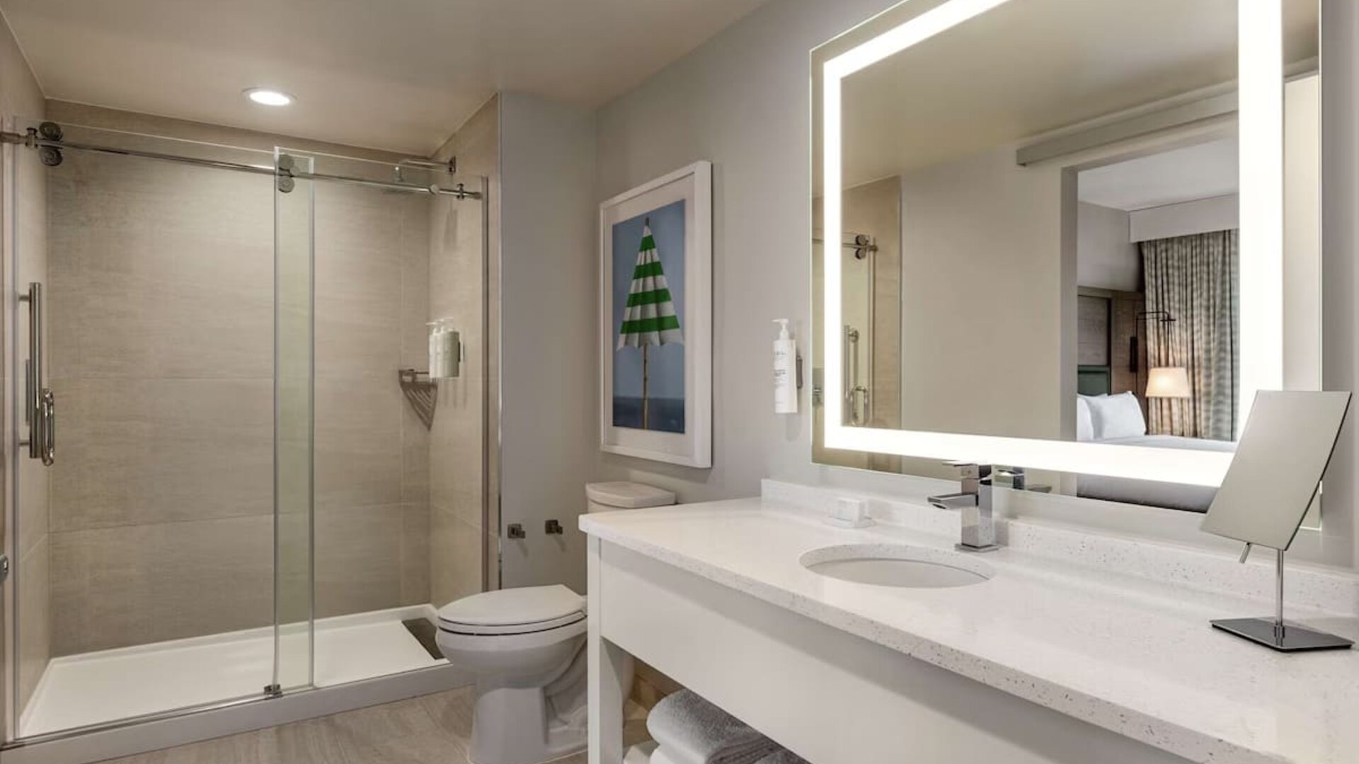 Private guest bathroom with shower and free toiletries at Embassy Suites By Hilton Panama City Beach Resort.