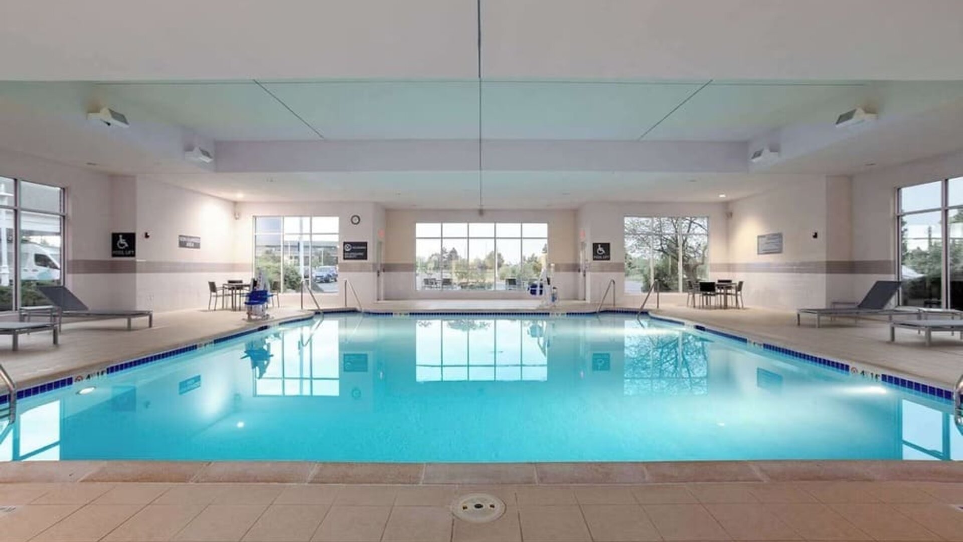 Relaxing indoor pool with lounge chairs at Hilton Garden Inn Milwaukee Northwest Conference Center.