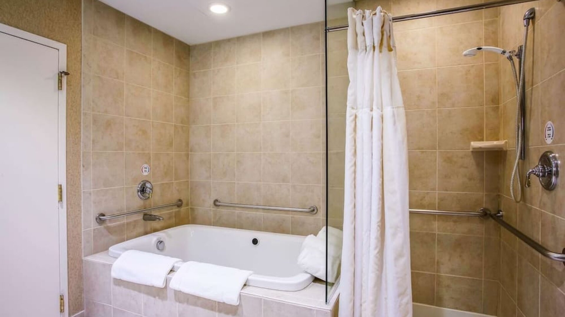 Private guest bathroom with tub and shower at Hilton Garden Inn Milwaukee Northwest Conference Center.