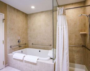 Private guest bathroom with tub and shower at Hilton Garden Inn Milwaukee Northwest Conference Center.