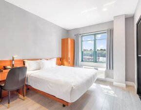 Day use room with work desk and natural light at Liberty View Brooklyn Hotel.
