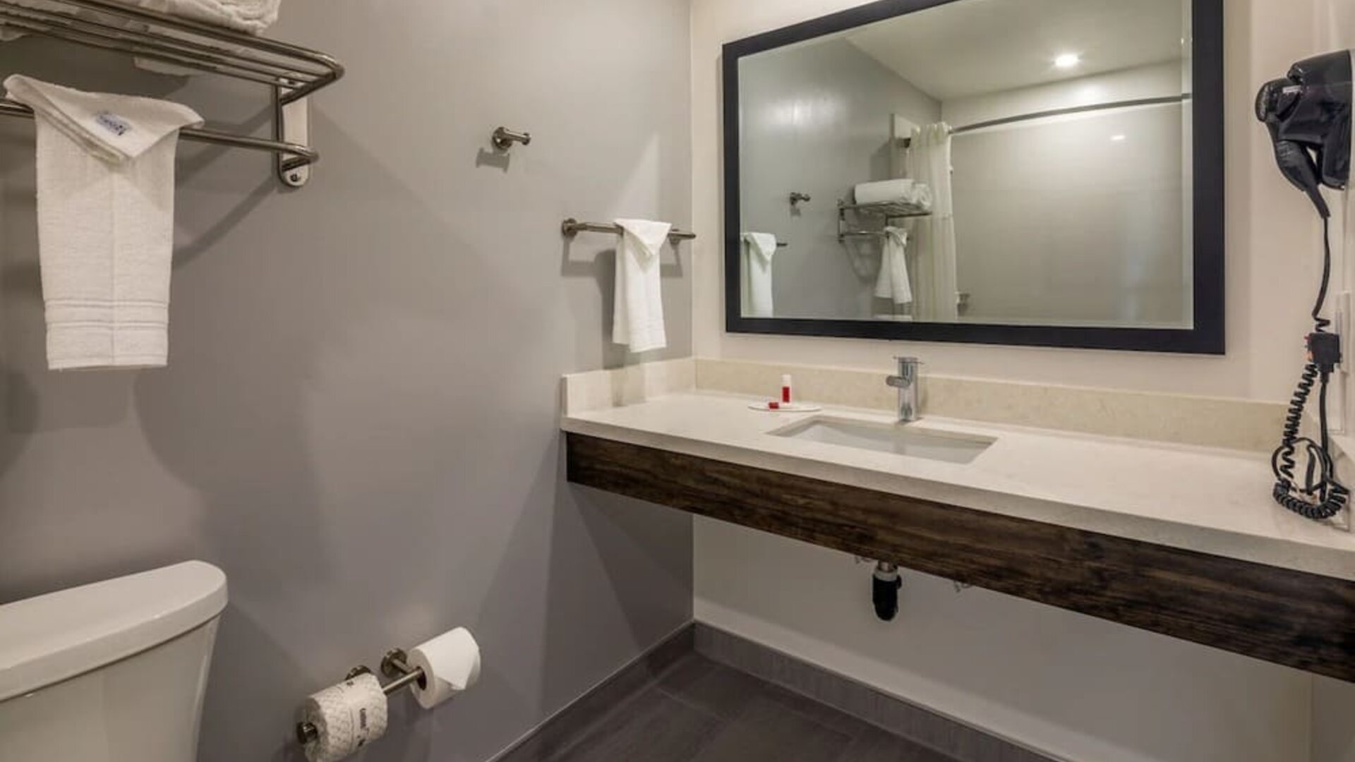 Private guest bathroom with shower and free toiletries at Travelodge LAX By Wyndham.