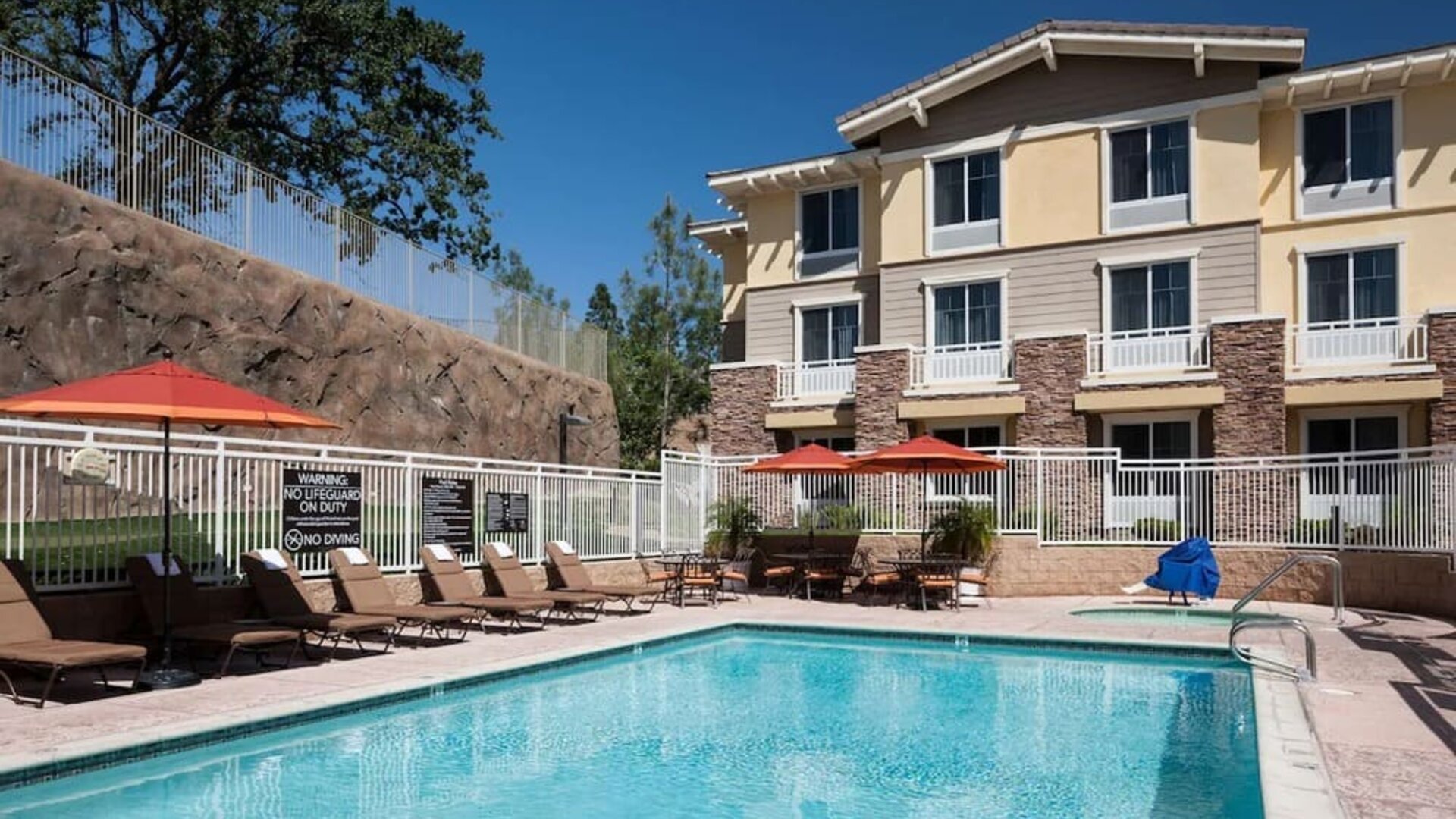 Outdoor pool with lounge chairs at Homewood Suites By Hilton Agoura Hills.