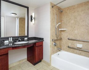Private guest bathroom with combined shower and tub at Homewood Suites By Hilton Agoura Hills.