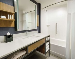 Private guest bathroom with combined shower and tub at Hilton Garden Inn Sunnyvale.