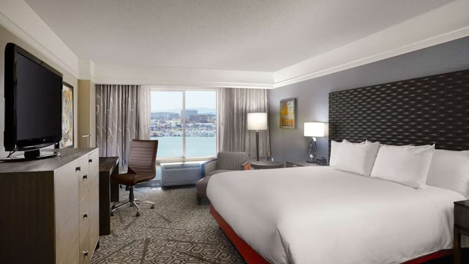 Day use room with king bed, work desk and TV screen at DoubleTree By Hilton San Francisco Airport North Bayfront.