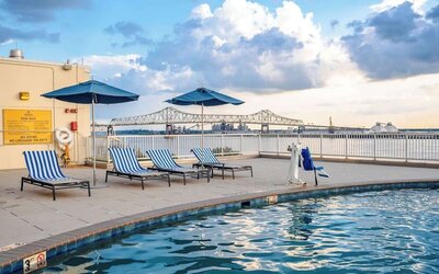 Outdoor pool with lounge seating and great city view at Hilton Baton Rouge Capitol Center.