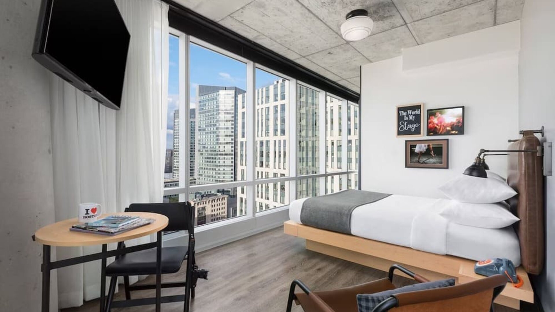Delux king room with work desk and a view of the city at Moxy Boston Downtown.