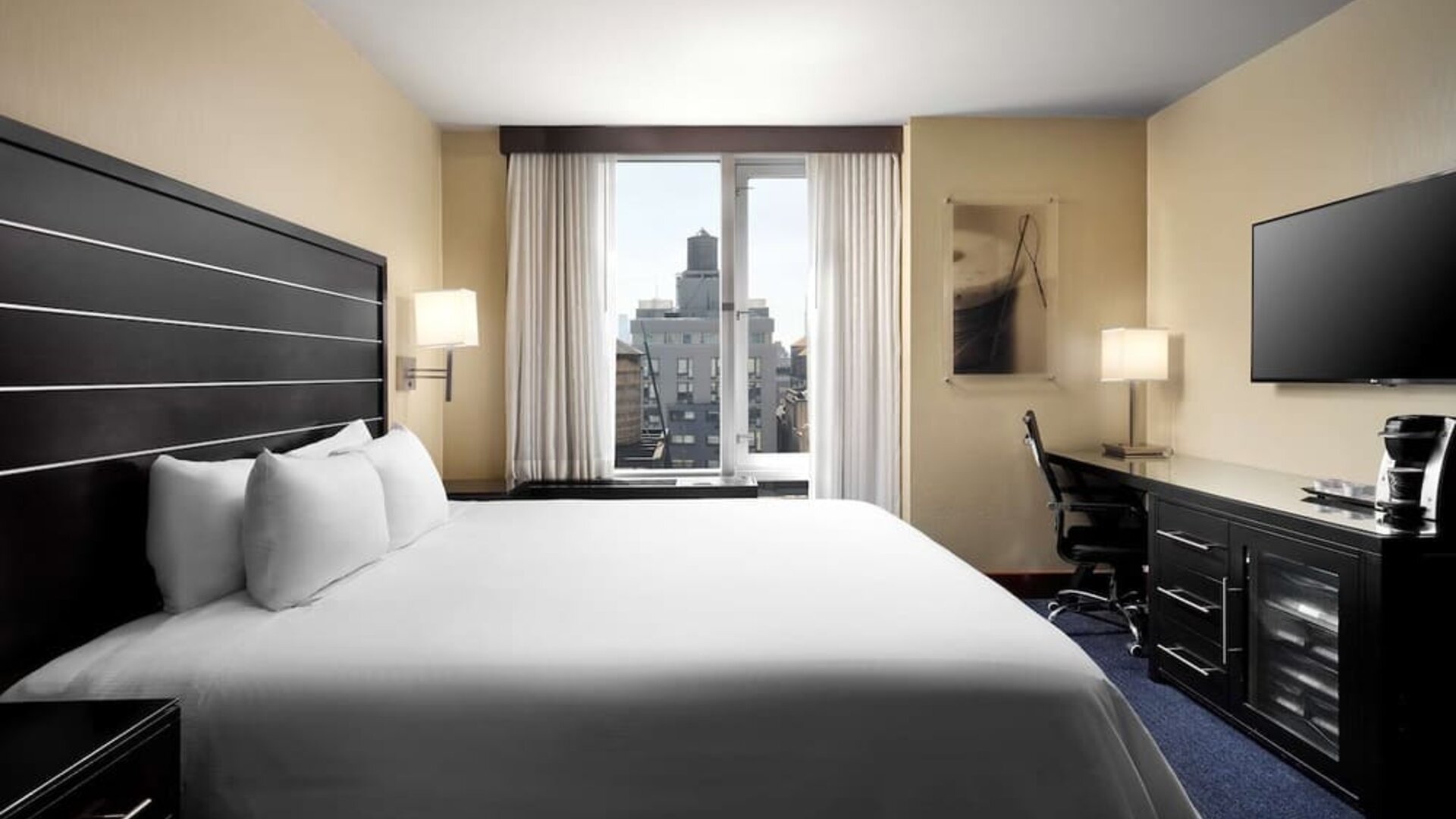 Delux king room with TV and work desk at Hilton New York Fashion District.
