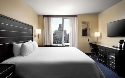 Delux king room with TV and work desk at Hilton New York Fashion District.