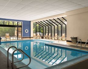 Indoor heated pool with lounge chairs at DoubleTree By Hilton Hartford - Bradley Airport.