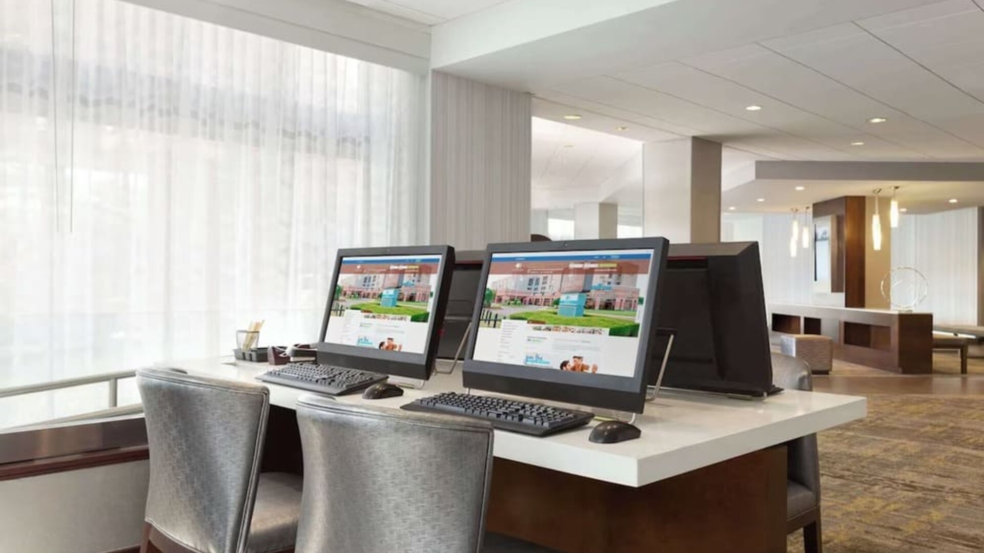 Business center with computers, printer and ergonomic chairs at DoubleTree By Hilton Hartford - Bradley Airport.