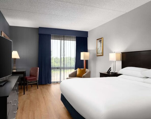 Day use room with floor to ceiling window, work desk, king bed and private bathroom at DoubleTree By Hilton Hartford - Bradley Airport.