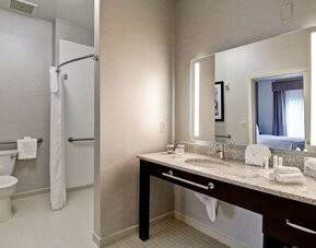Private guest bathroom with shower and free toiletries at Homewood Suites By Hilton Newark-Cranford.