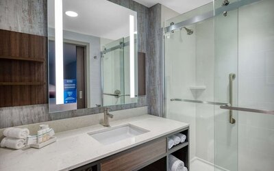 Private guest bathroom with shower at Hilton Garden Inn Boston Logan Airport.