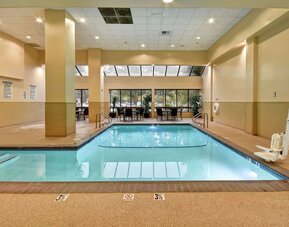 Relaxing indoor pool with seating area at Embassy Suites By Hilton Santa Clara Silicon Valley.