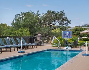One of the 3 outdoor pools with loungers at Hilton San Antonio Hill Country.