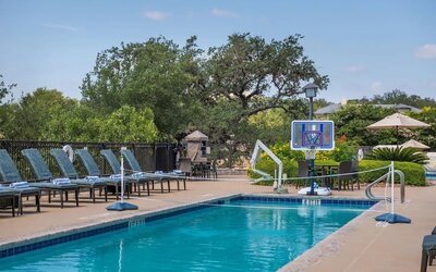 One of the 3 outdoor pools with loungers at Hilton San Antonio Hill Country.