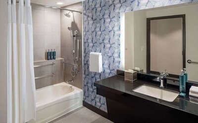 Guest bathroom with shower and tub at Hilton San Antonio Hill Country.