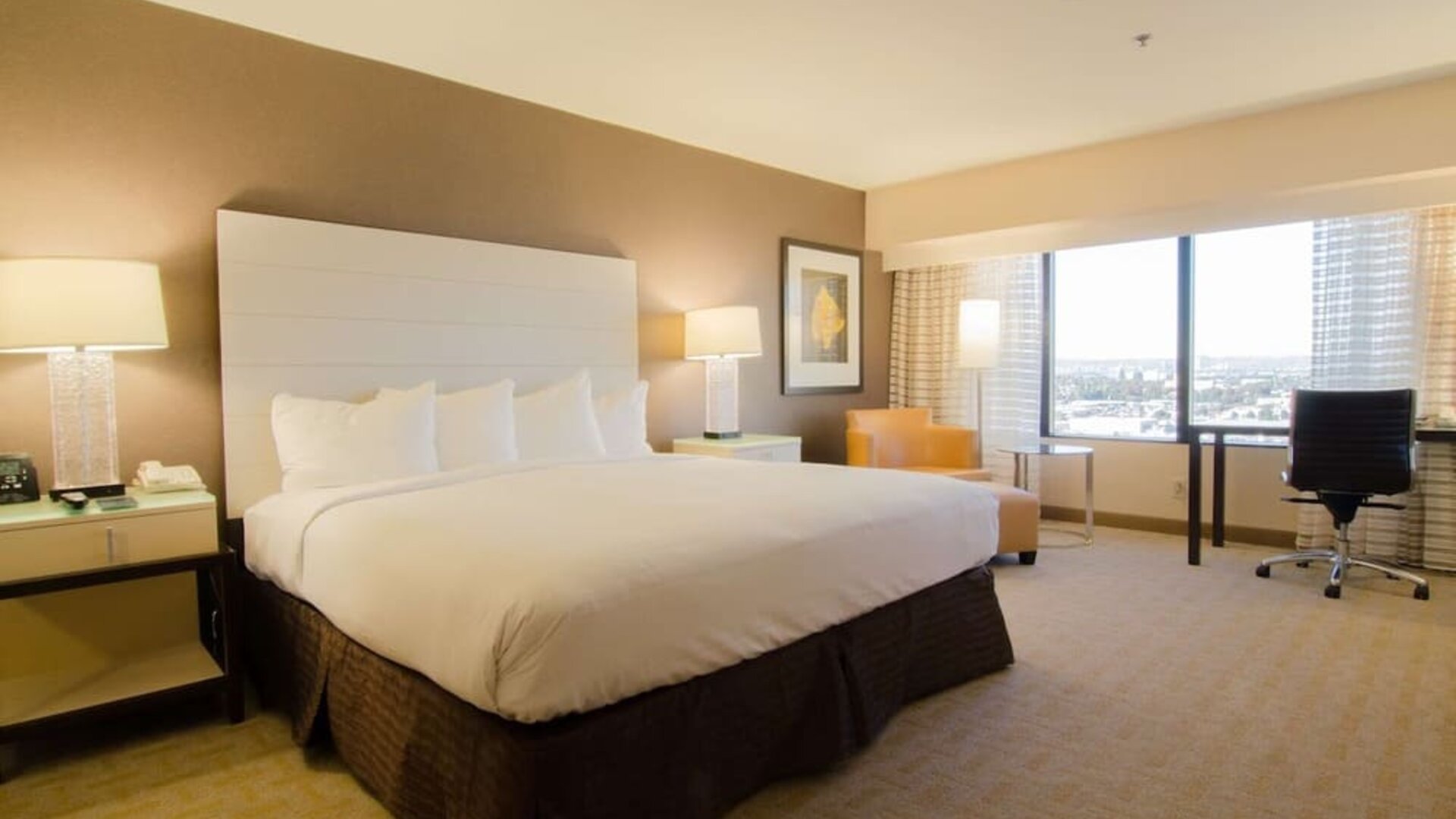 Delux king room with work desk and natural light at Hilton Los Angeles Airport.