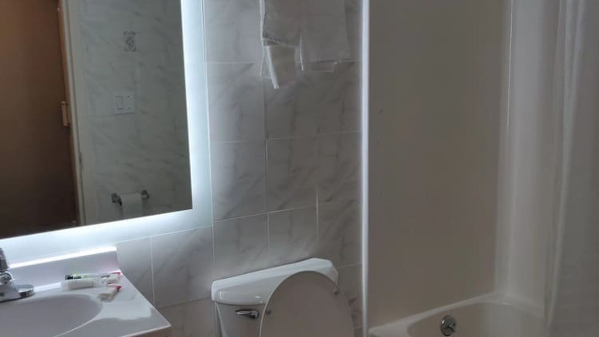 Guest bathroom with shower and tub at Hotel Key.