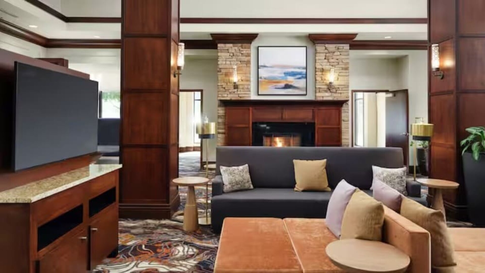 Lobby lounge area with comfortable seating, TV screen and fireplace at Hilton Garden Inn Shreveport Bossier City.