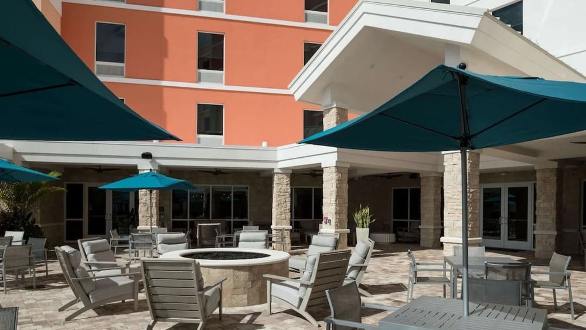 Patio with lounge seating and fire pit at Home2 Suites By Hilton Cape Canaveral Cruise Port.