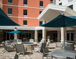 Patio with lounge seating and fire pit at Home2 Suites By Hilton Cape Canaveral Cruise Port.