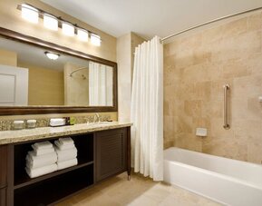 Private guest bathrooom with combined shower and tub at Embassy Suites By Hilton Savannah.