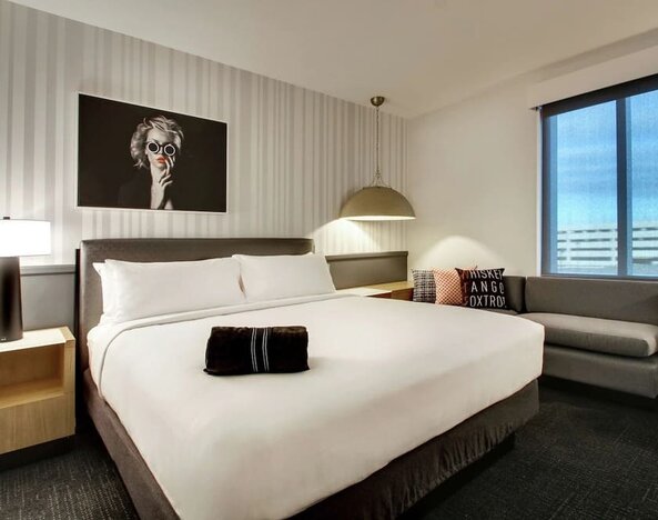 Day use room with sofa and work desk at The Rose Hotel Chicago O’Hare, Tapestry Collection By Hilton.