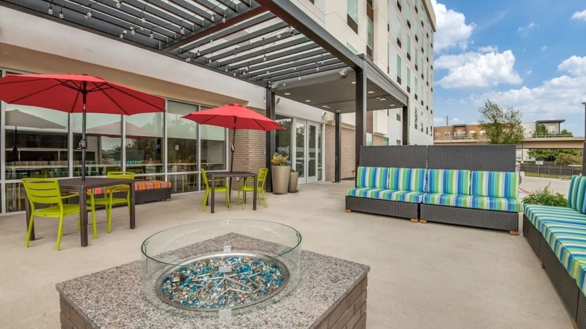Hotel terrace with lounge seating and fire pit at Home2 Suites By Hilton Dallas Medical District Lovefield.