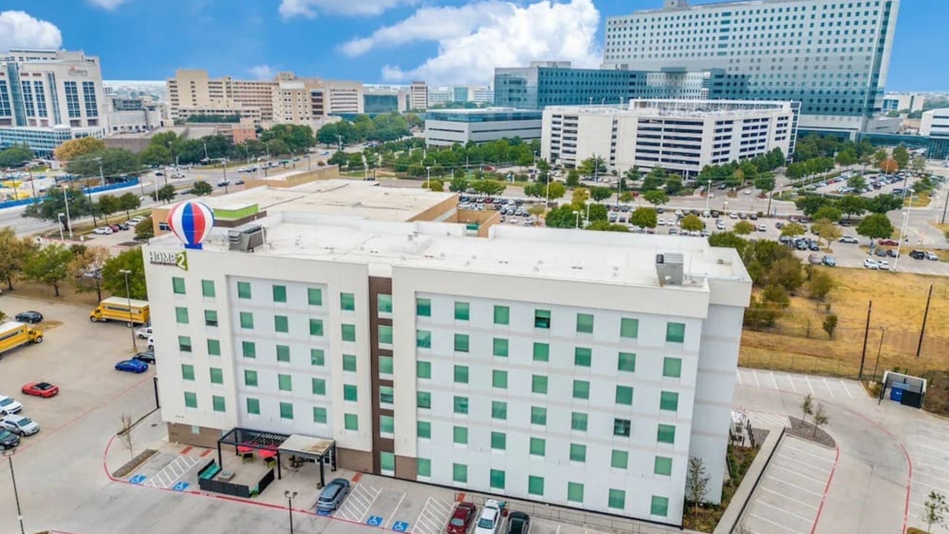 Exterior view of Home2 Suites By Hilton Dallas Medical District Lovefield and its parking area. 