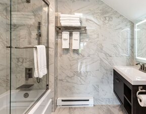 Private guest bathroom with combined shower and tub at SKYLARANNA Resort & Spa.