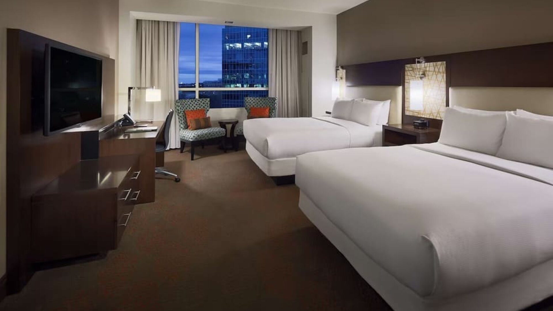 Day use twin room with workspace and lounge seating at Hilton Dallas/ Plano Granite Park.
