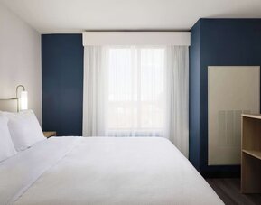 Day use room with king bed and tv at Spark By Hilton Guelph.