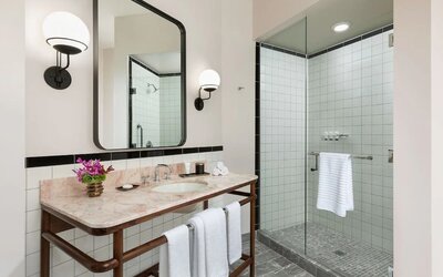 Private guest bathroom with shower at The Candler Hotel Atlanta, Curio Collection By Hilton.