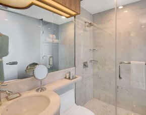 Private guest bathroom with shower and free toiletries at Wyndham Garden Brooklyn Sunset Park.