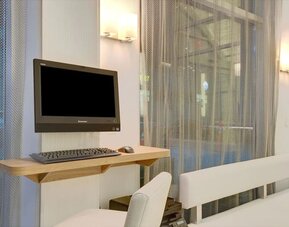 Business center with computer, printer and comfortable seating at Wyndham Garden Brooklyn Sunset Park.