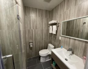 Private guest bathroom with shower and free toiletries at King Hotel Brooklyn.