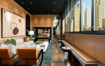Lounge seating and workspace with fireplace at AC Hotel New York Times Square.