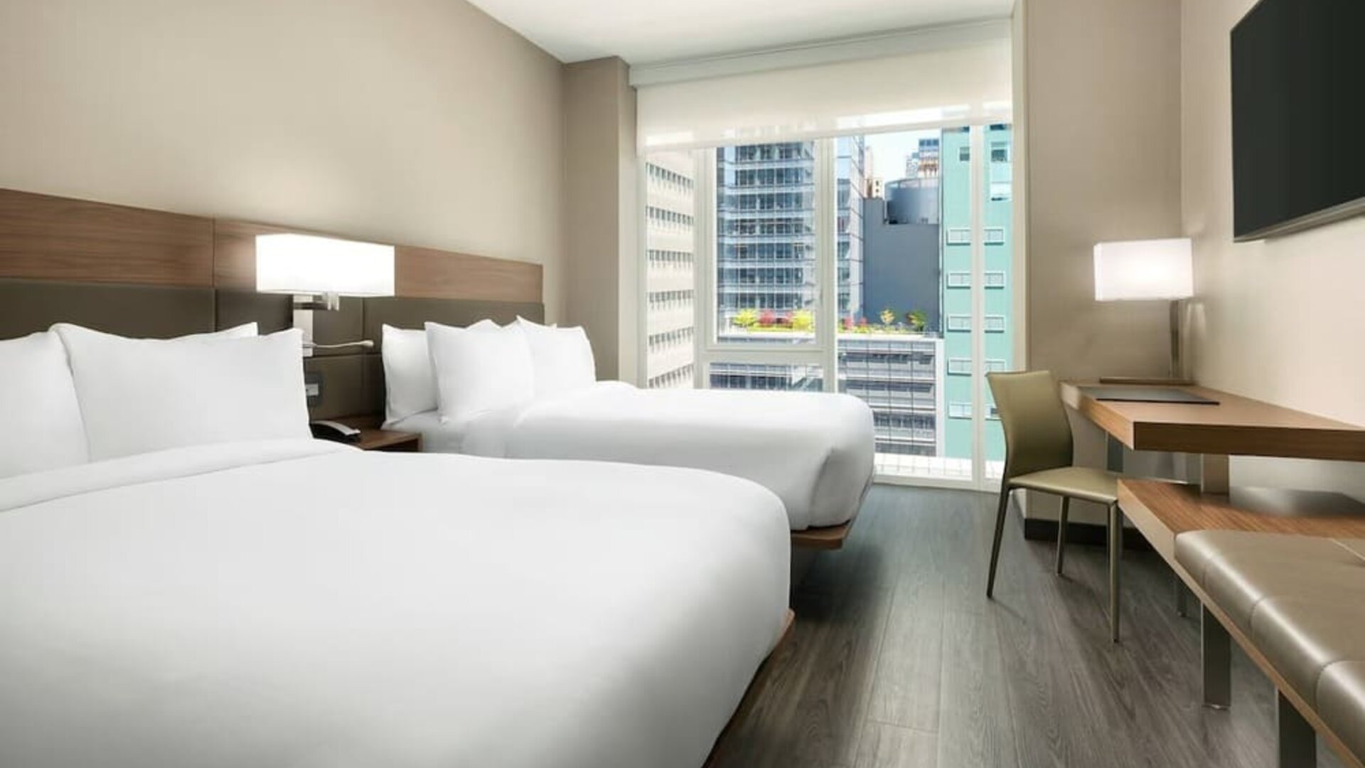 Day use twin room with workspace, floor to ceiling window and private bathroom at AC Hotel New York Times Square.
