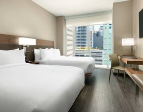 Day use twin room with workspace, floor to ceiling window and private bathroom at AC Hotel New York Times Square.