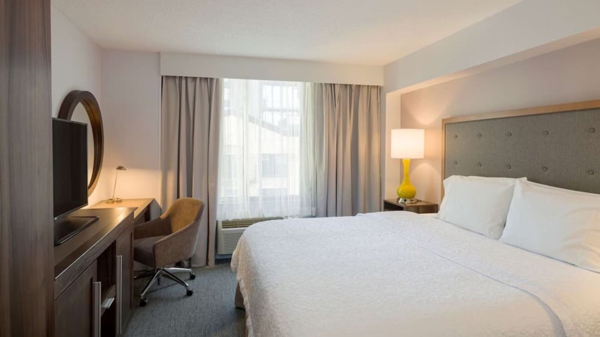 Day use room with king bed, work desk, natural light and private bathroom at Hampton Inn Manhattan Chelsea.