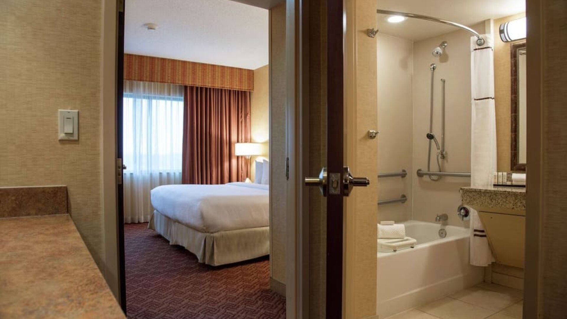 Guest bathroom with tub and shower at Embassy Suites By Hilton Charlotte-Concord-Golf Resort & Spa.